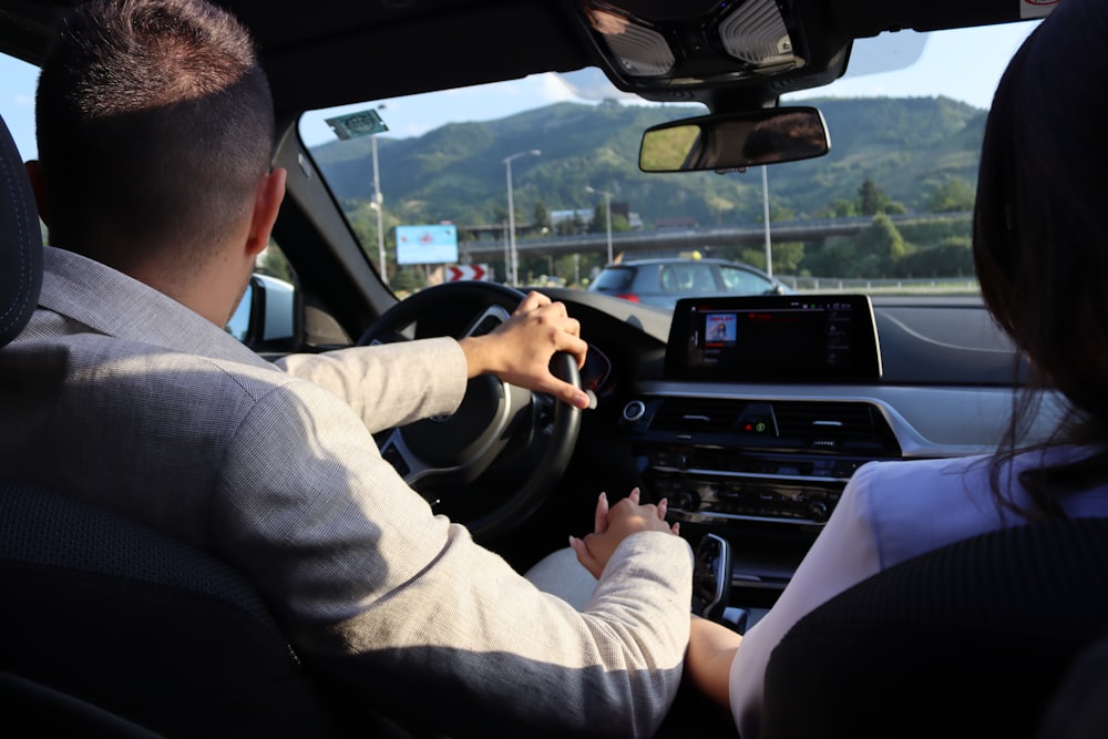 a man and a woman are driving a car