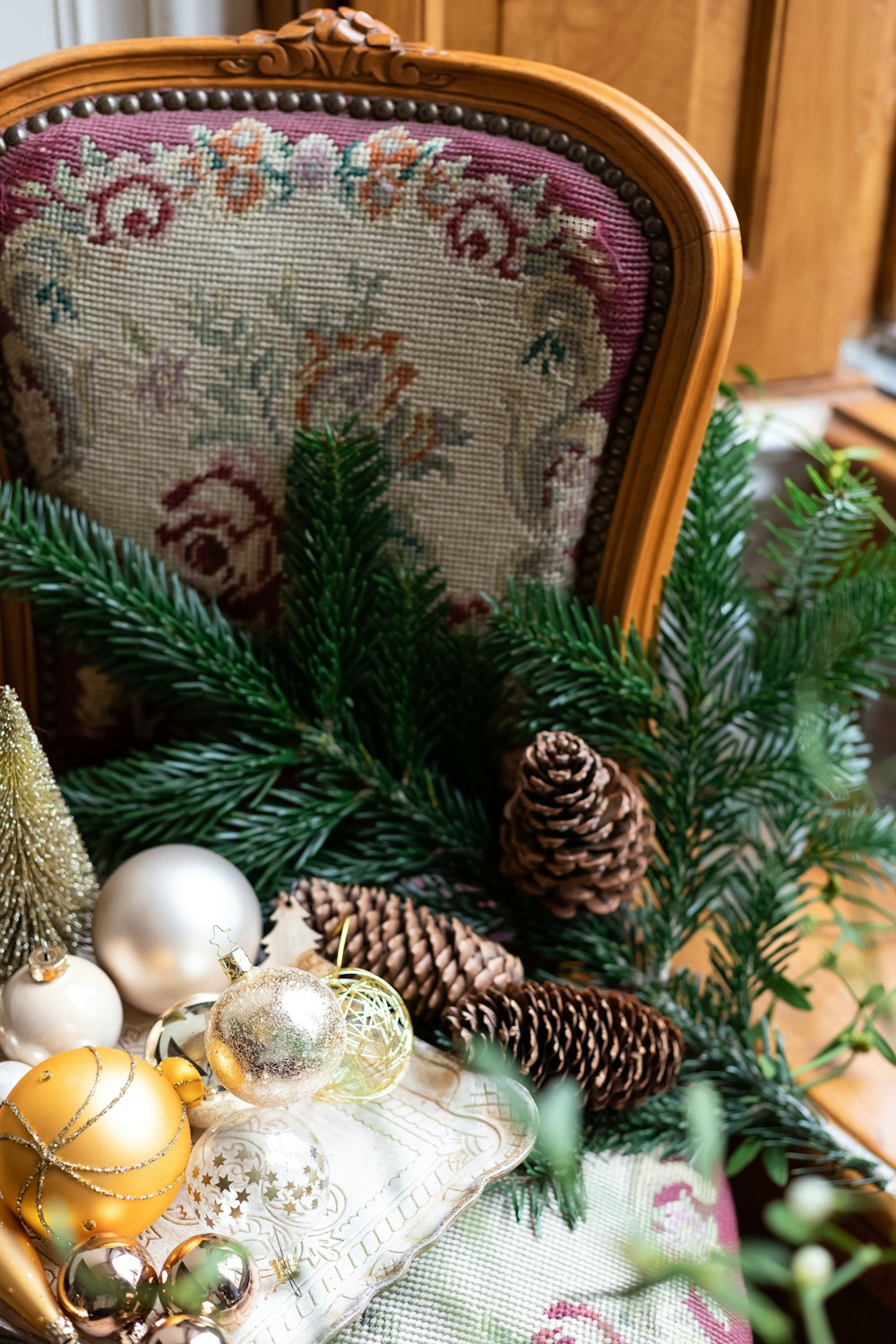 a chair with christmas decorations and pine cones on it