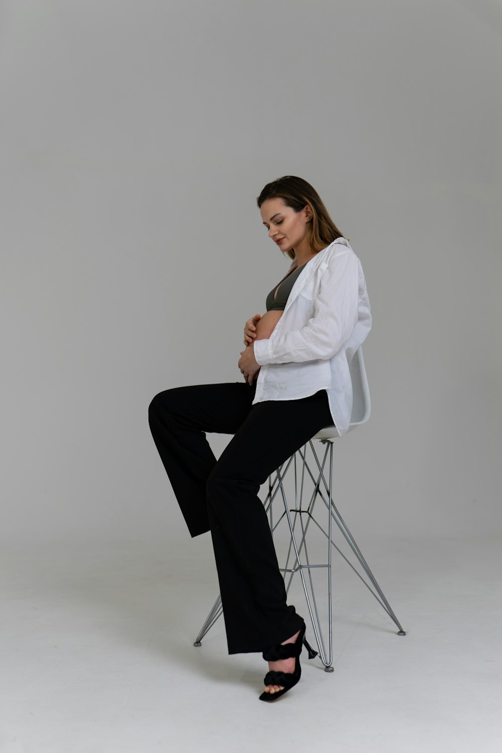 Una donna seduta su una sedia con le gambe incrociate