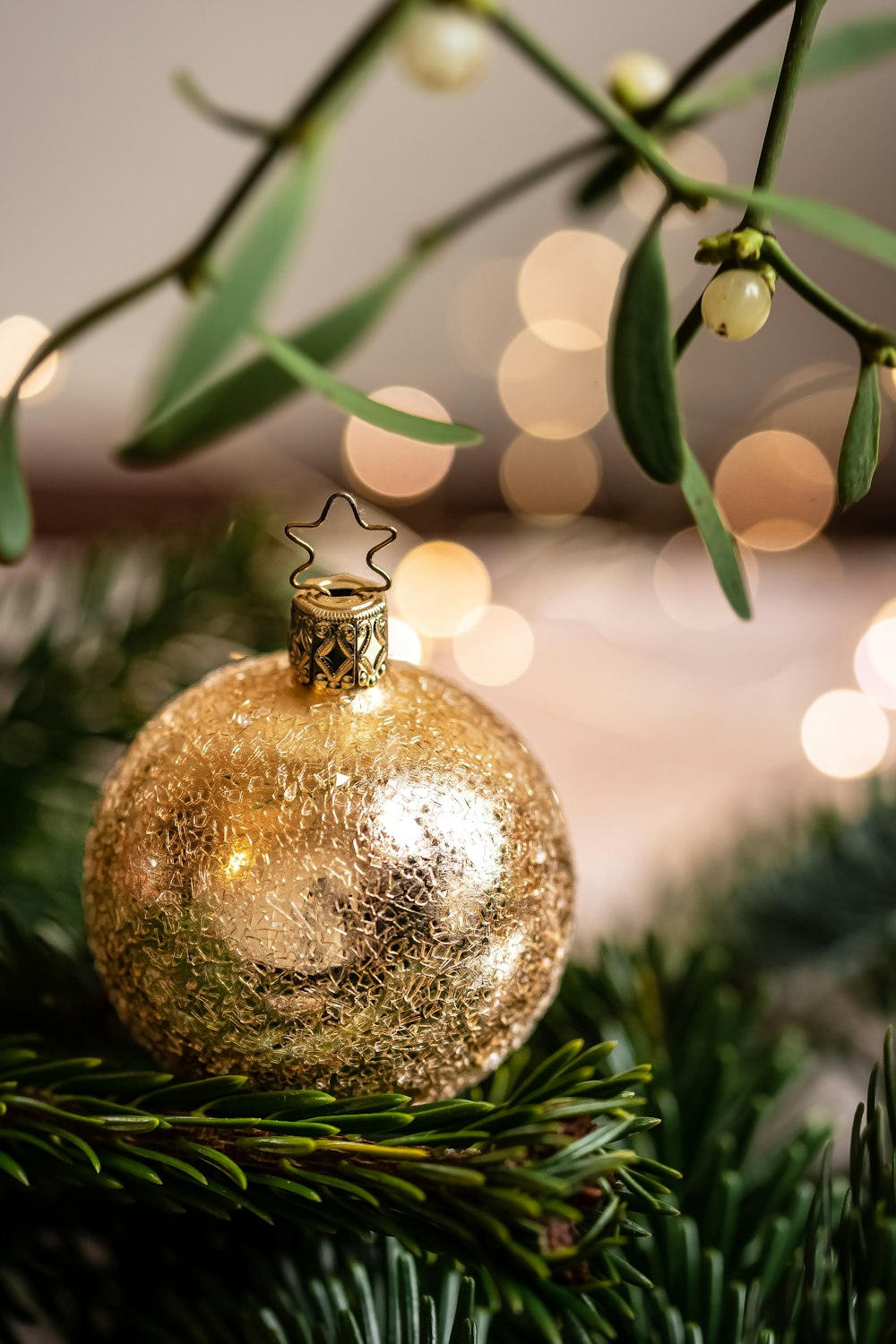 a gold ornament hanging from a christmas tree