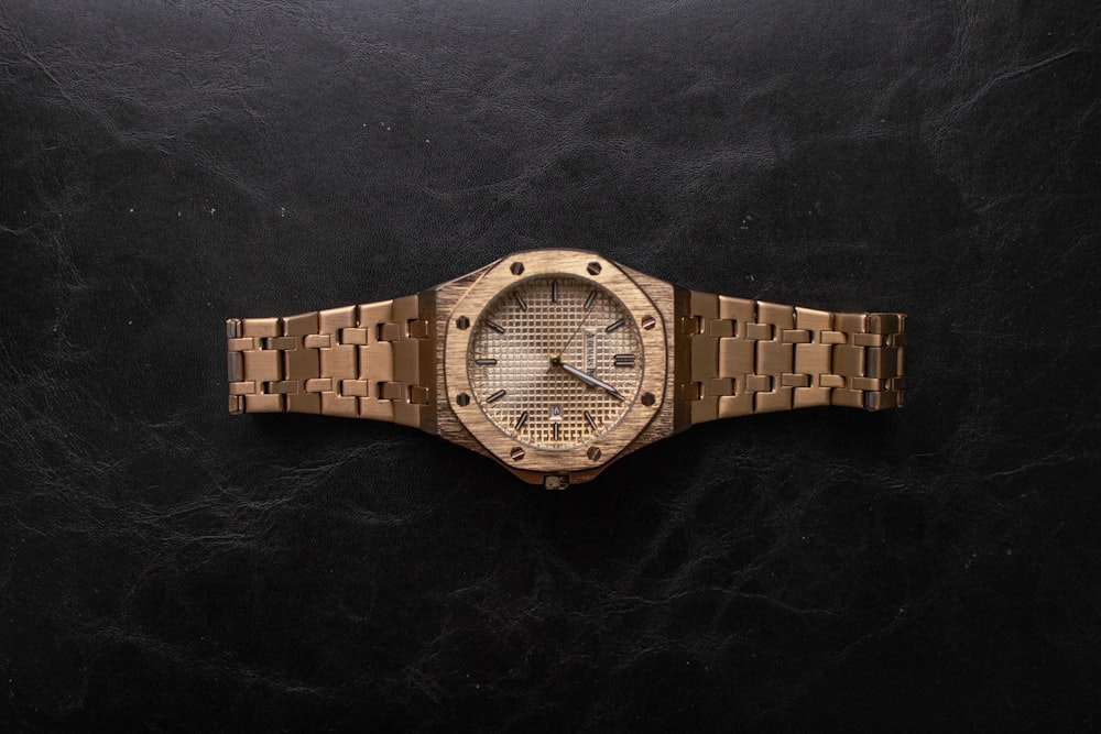 a wooden watch sitting on top of a black surface
