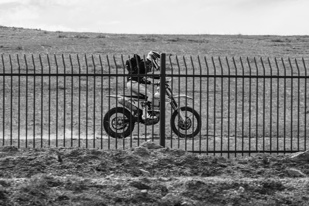 a person riding a dirt bike behind a fence