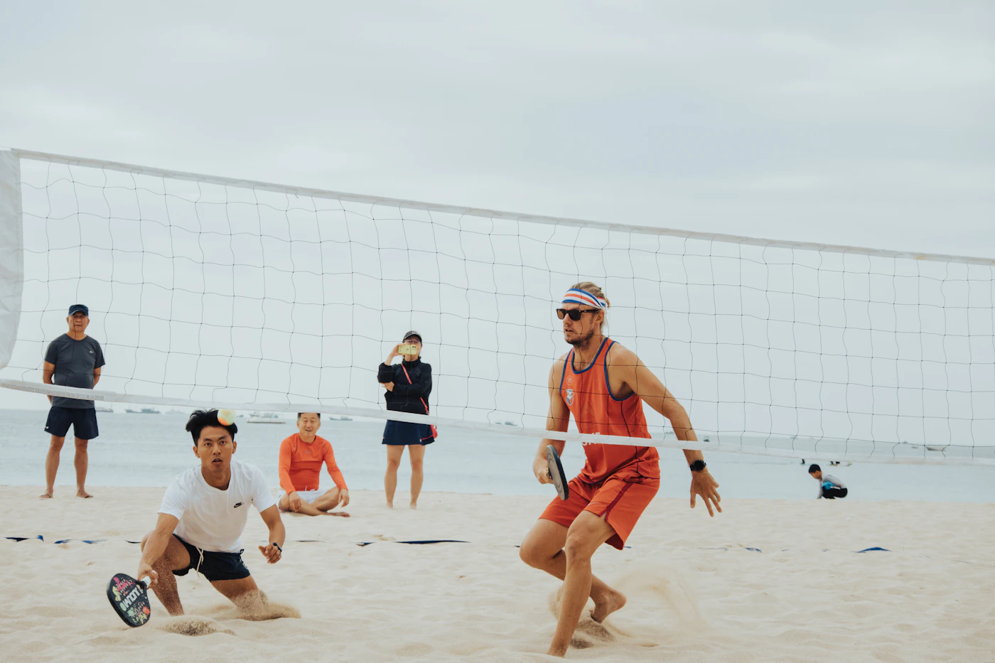 Jogadores disputando uma partida de beach tennis na areia