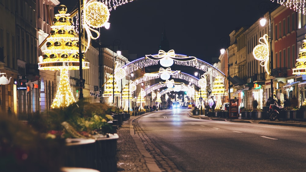 a city street is lit up with christmas lights