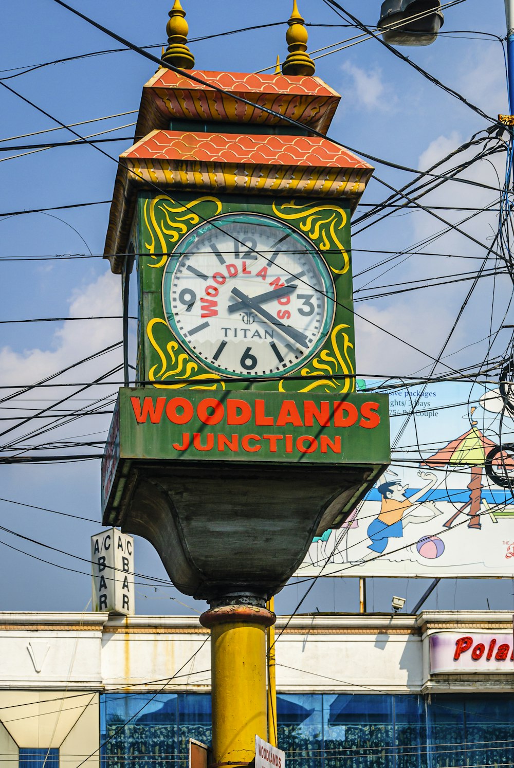 a clock on top of a pole in front of power lines