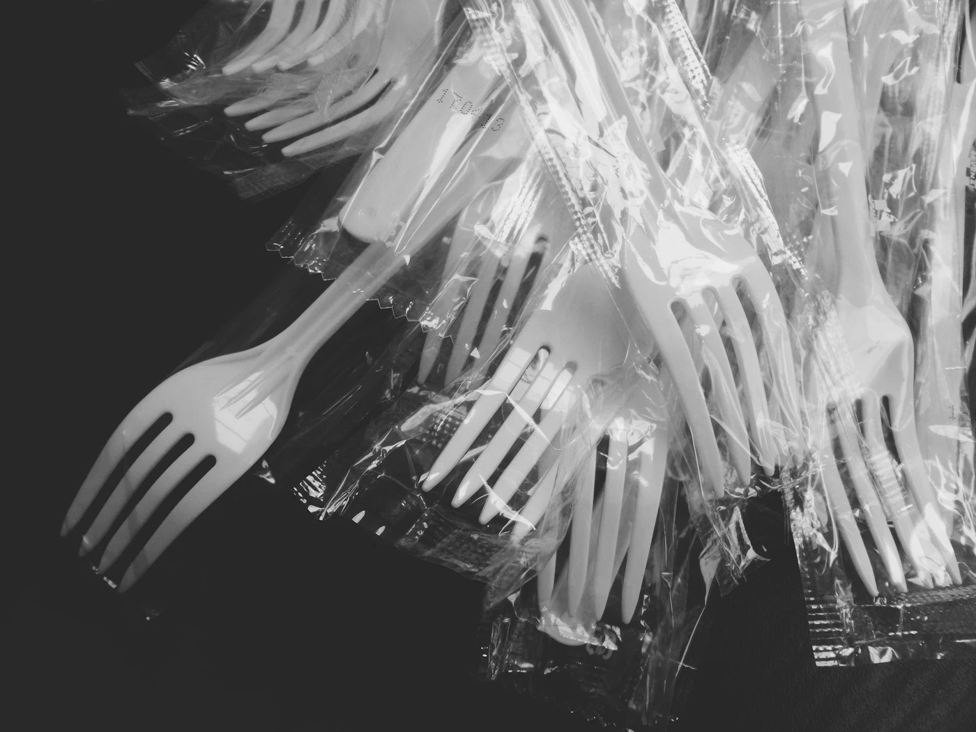 Tas de fourchettes jetables en plastique gris sur une table