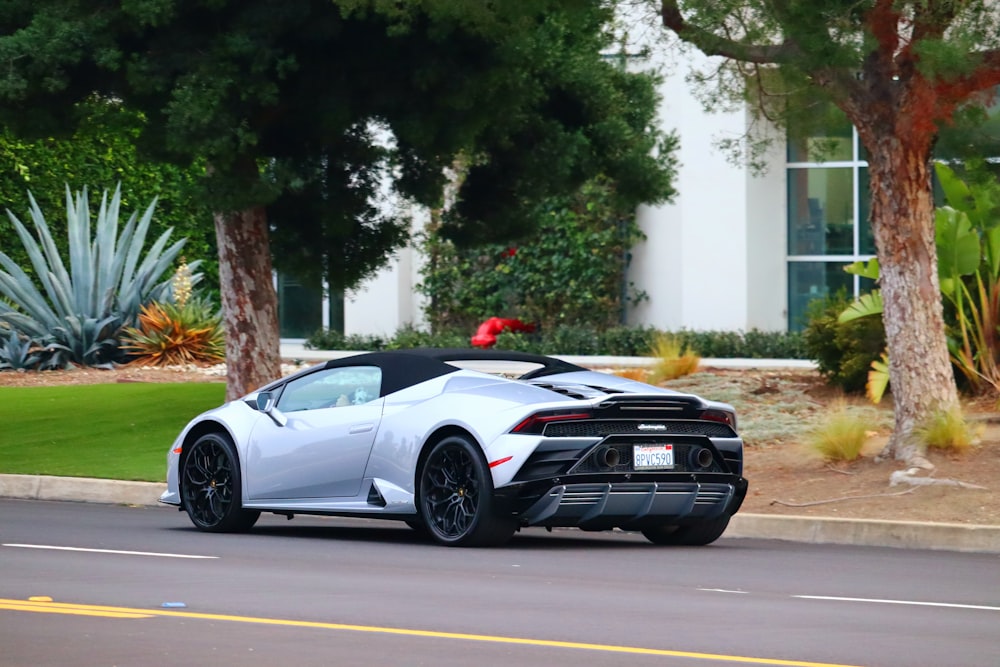 a white sports car driving down a street