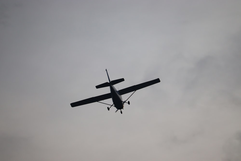 a small airplane flying through a cloudy sky