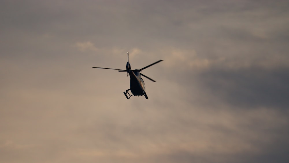 a helicopter flying through a cloudy sky