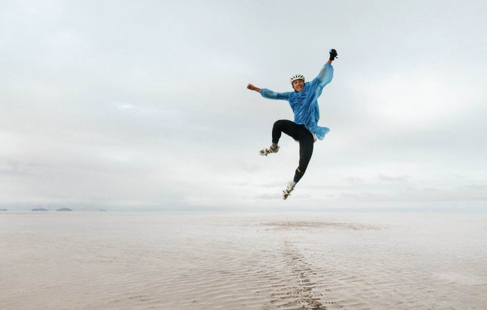 a man is jumping in the air on the beach