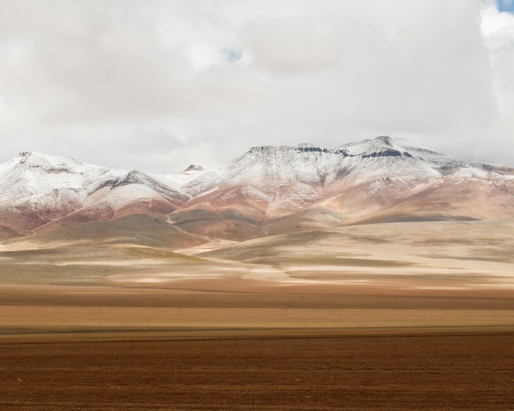 Die Berge sind mit Schnee und braunem Gras bedeckt