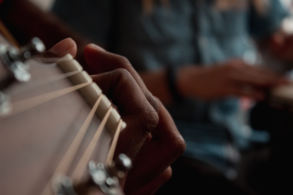 a close up of a person playing a guitar