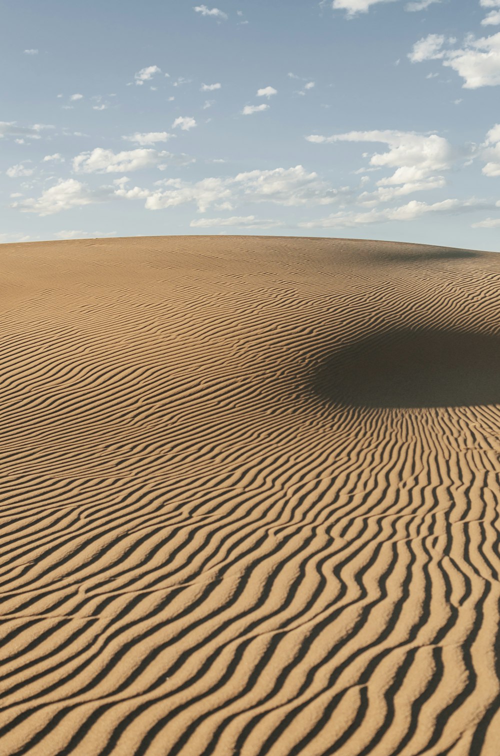 a large sand dune with a sky background