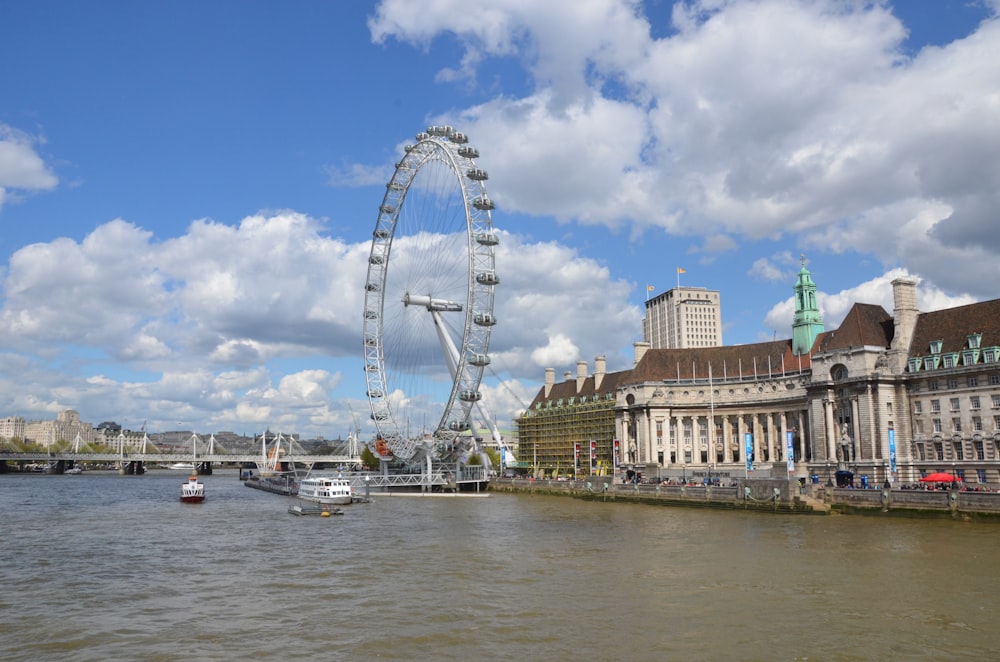 a large ferris wheel sitting next to a river