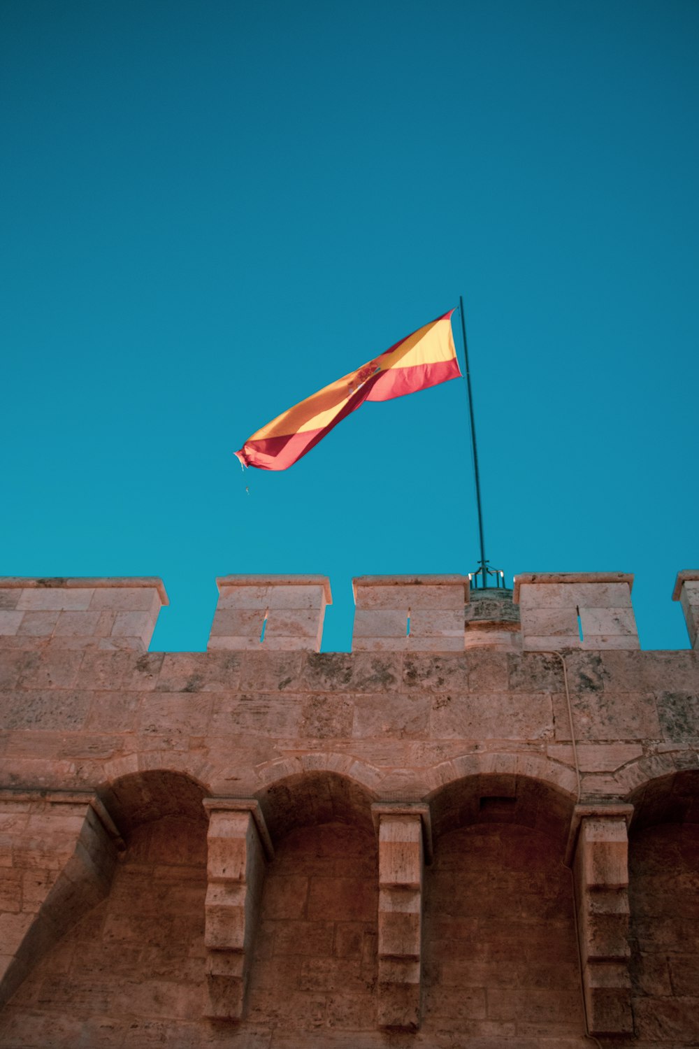 a red and yellow flag on top of a building