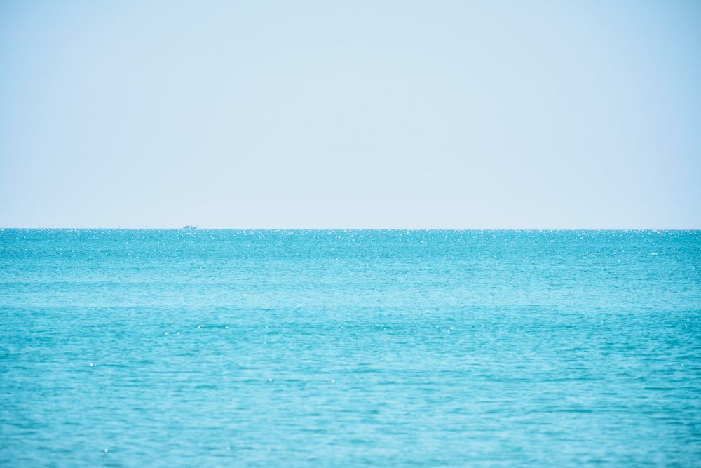 a large body of water sitting under a blue sky