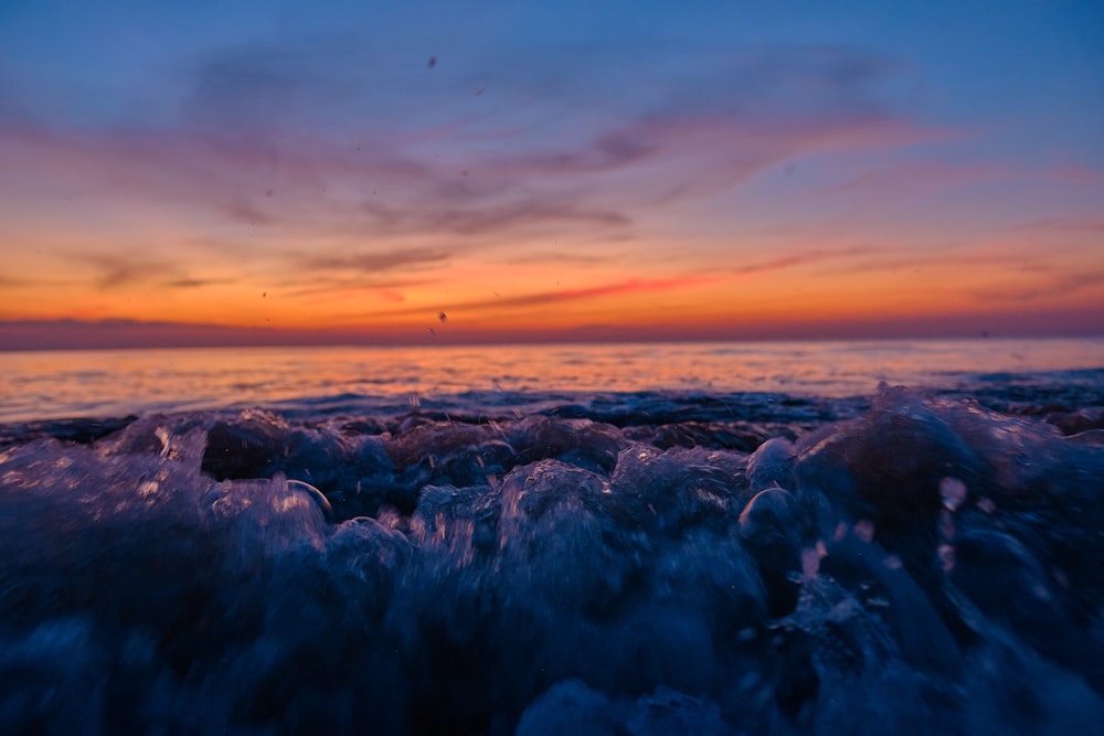 a sunset over a body of water with waves