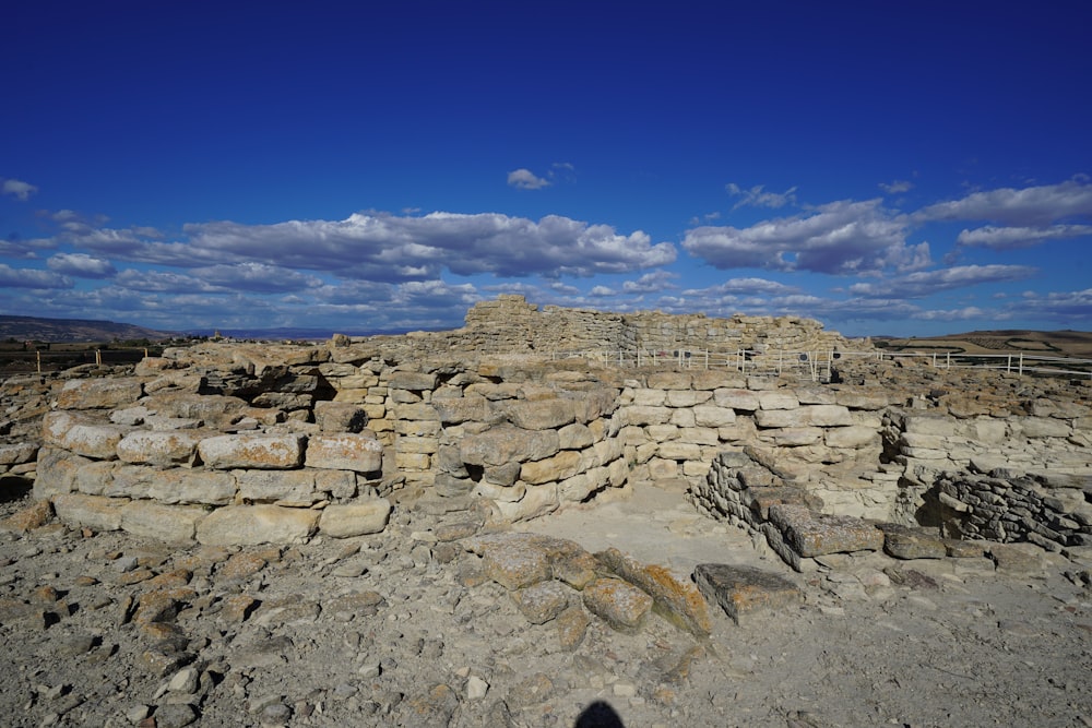 a large stone structure sitting on top of a dirt field