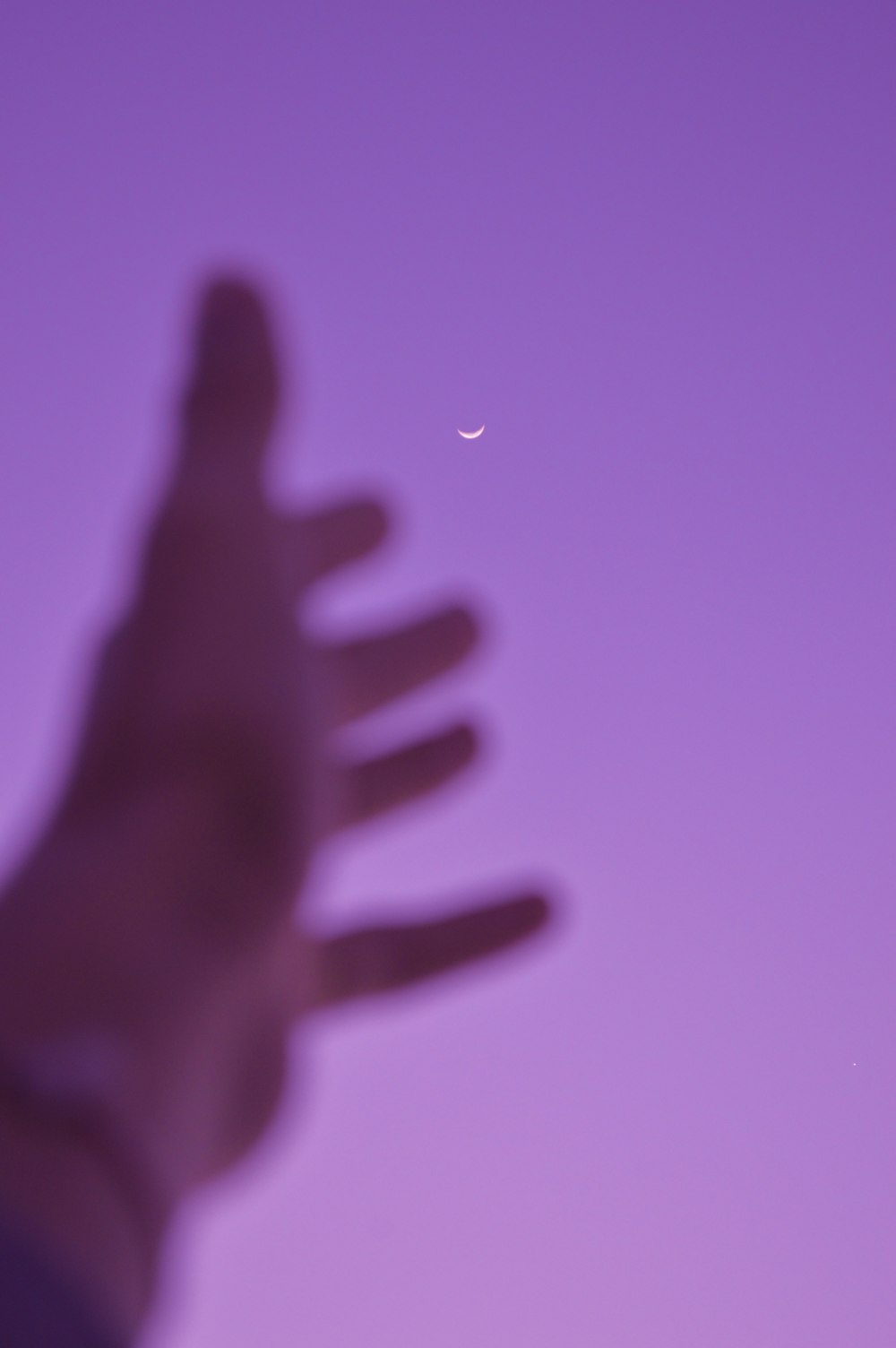 uma foto borrada da mão de uma pessoa com uma meia-lua no
