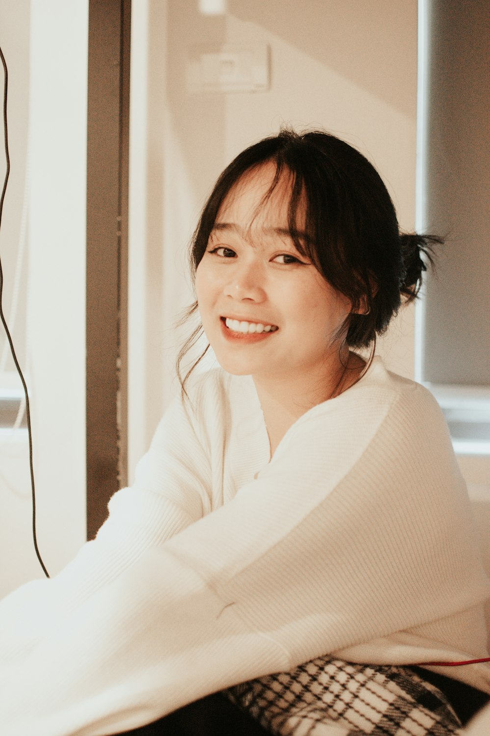 a woman sitting on a bed smiling at the camera