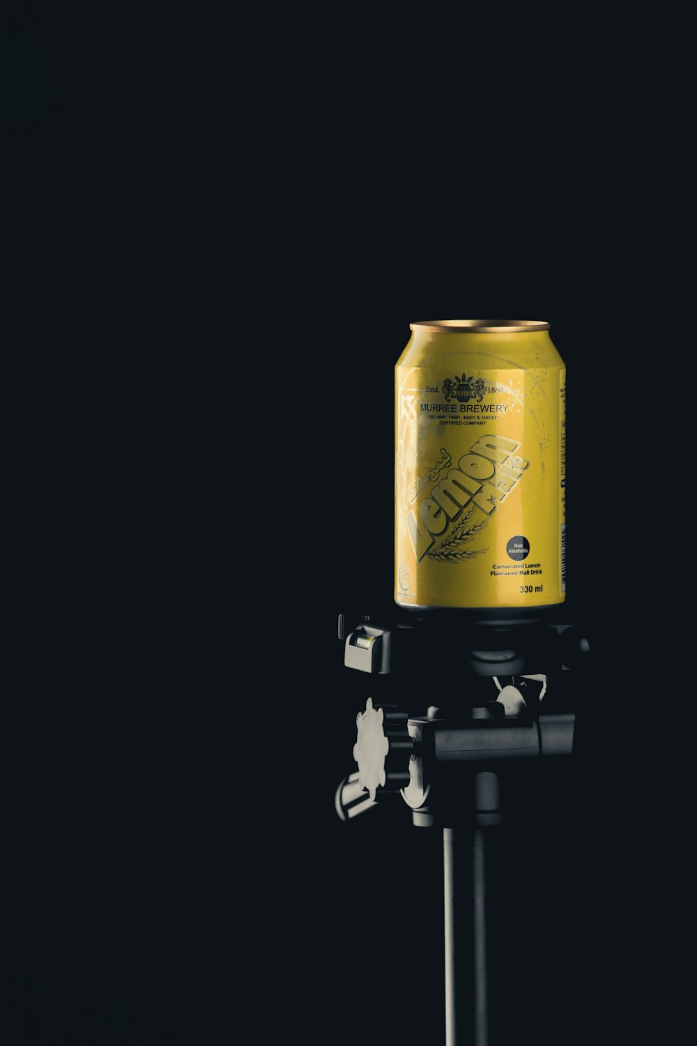 a can of beer sitting on top of a tripod