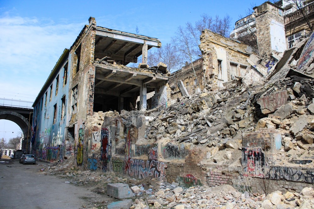 an old building with graffiti on it and a bridge in the background