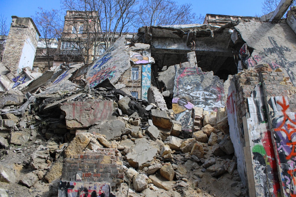 a pile of rubble next to a building with graffiti on it