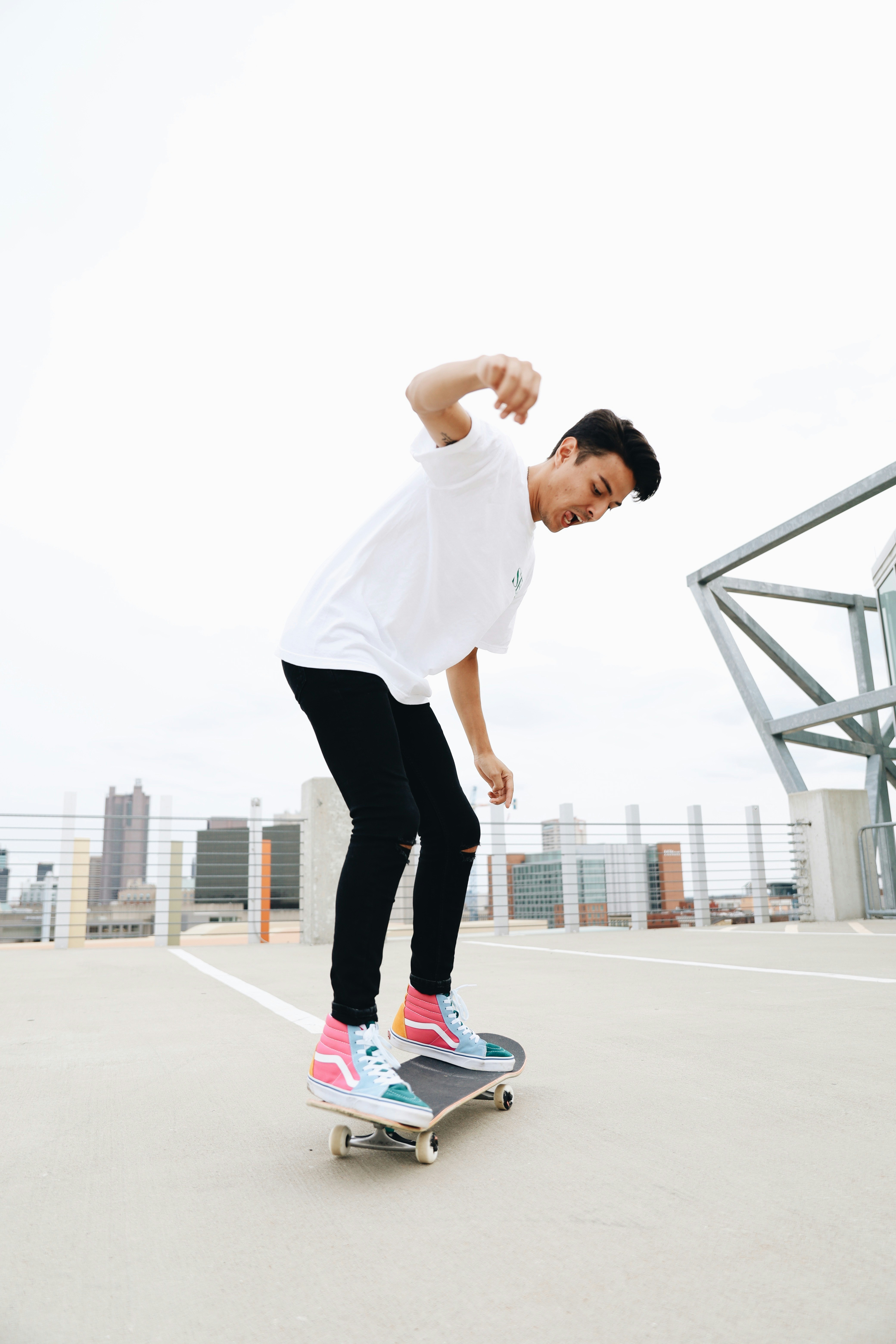 Un uomo che cavalca uno skateboard in cima a un parcheggio