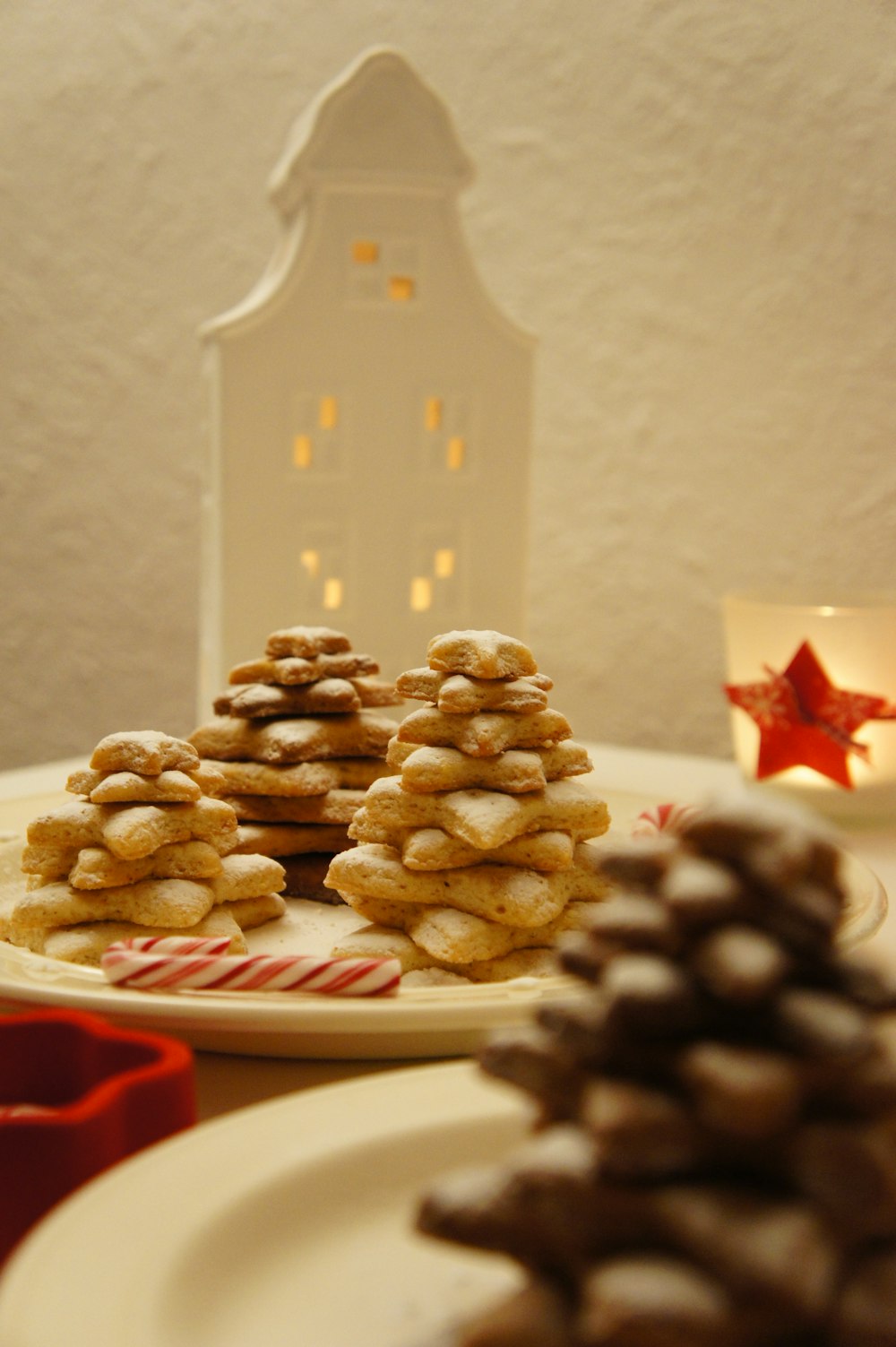 a white plate topped with cookies next to a lit candle