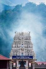 a very tall white temple with a clock on it's side