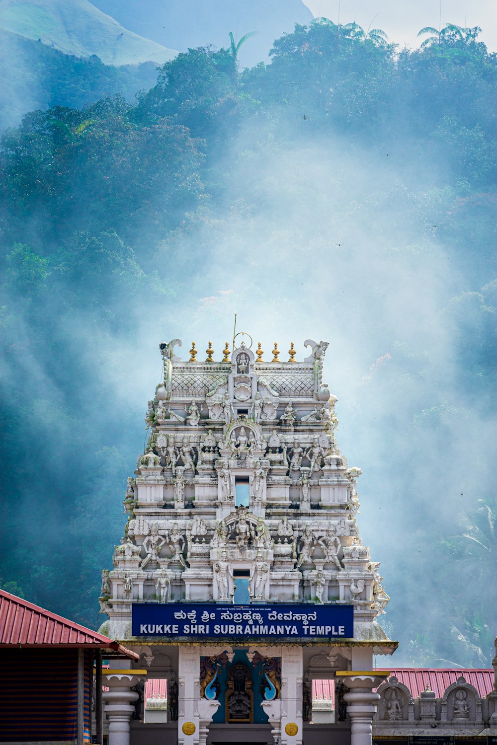 a very tall white temple with a clock on it's side