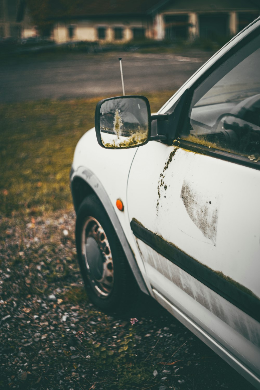 a white car parked on top of a grass covered field