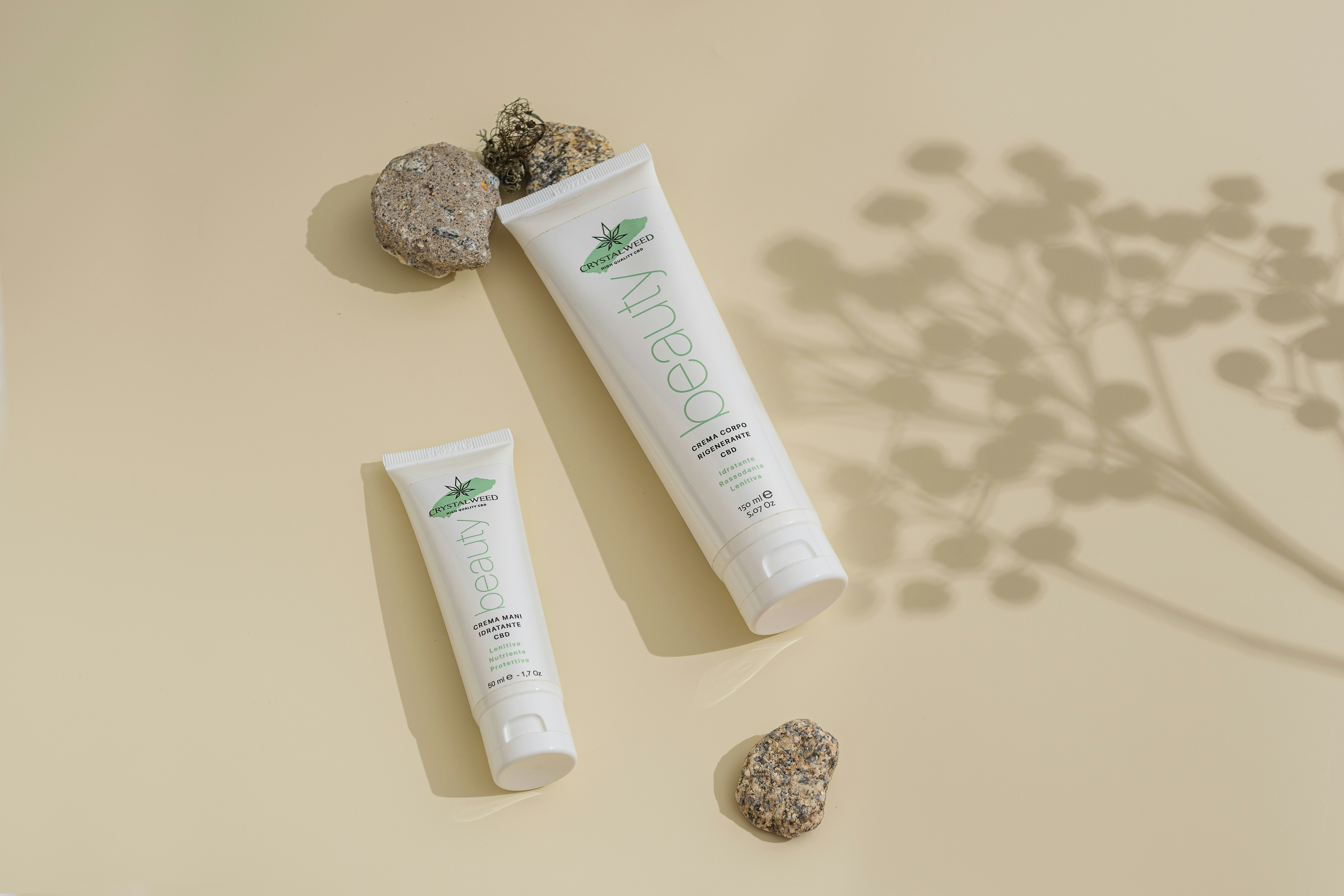 A couple of tubes of toothpaste next to a rock photo Free Bottle