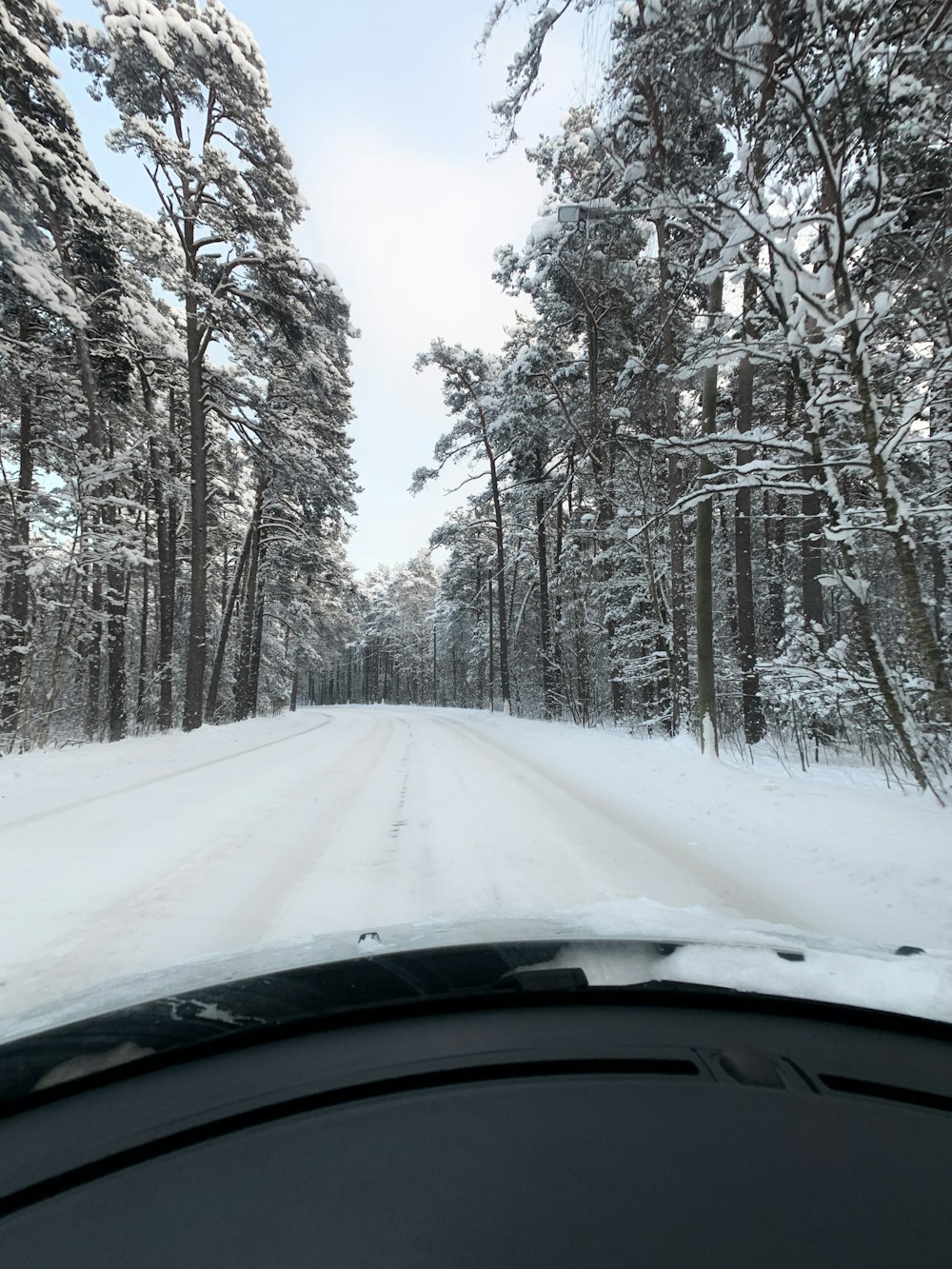 Ein Auto fährt eine schneebedeckte Straße hinunter