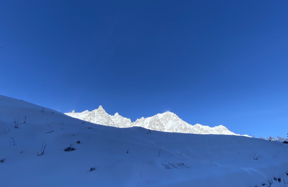 a snow covered mountain under a blue sky