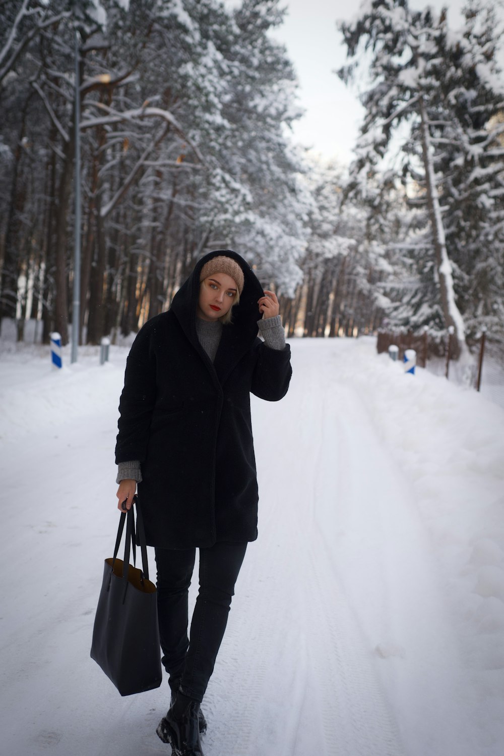 a person walking in the snow with a bag