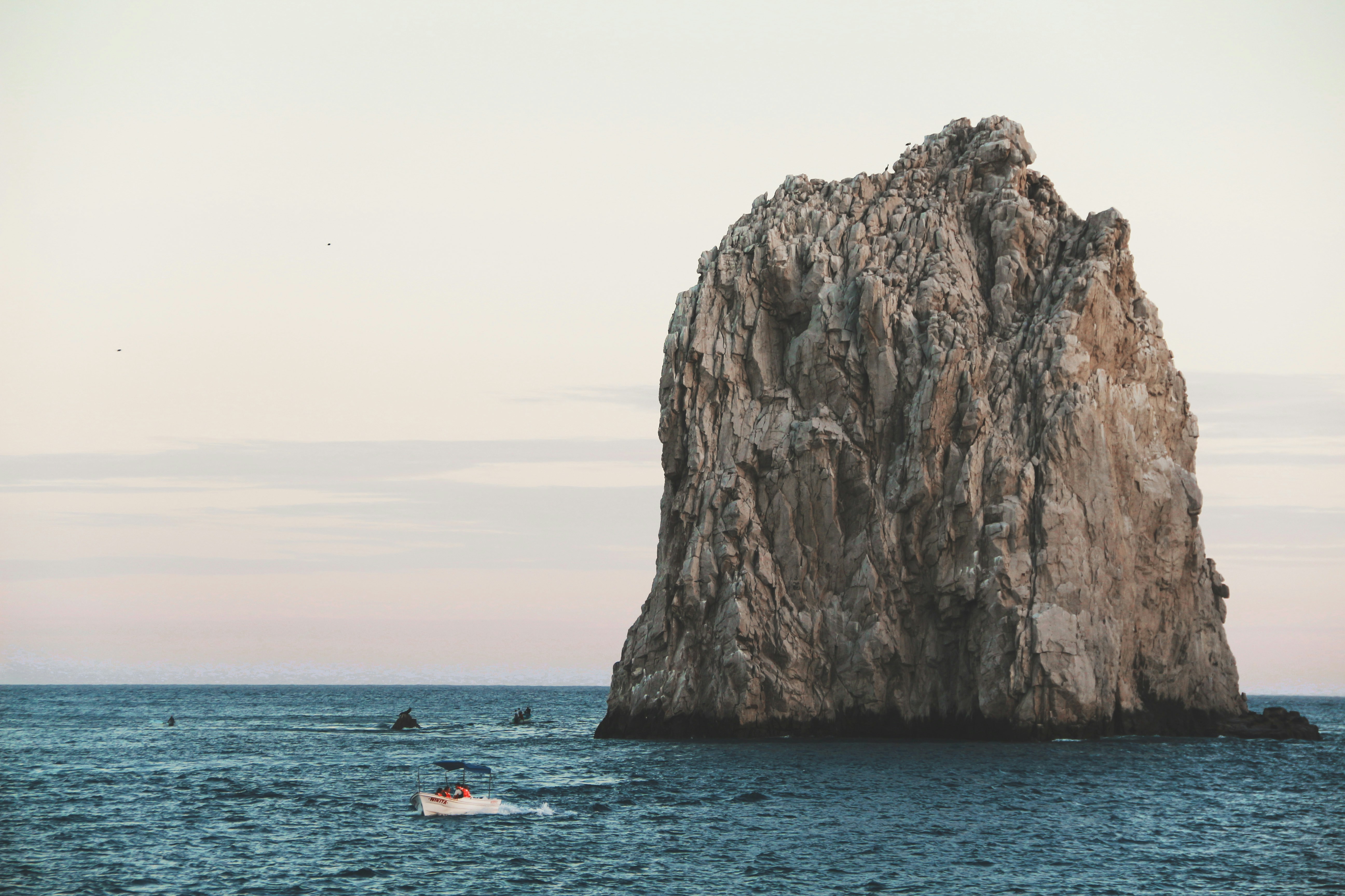 a large rock in the middle of the ocean, 