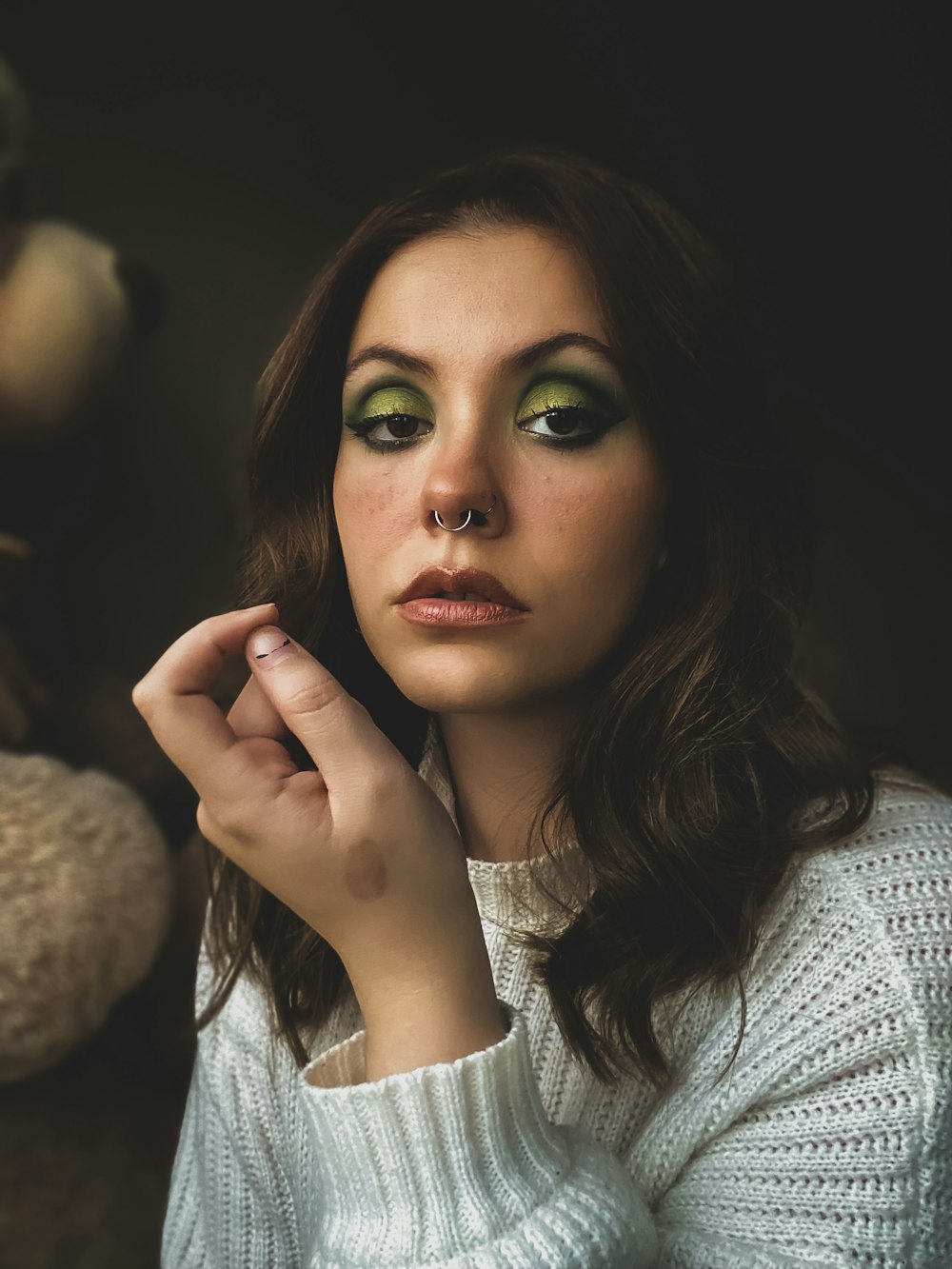 a woman with green eyes and a white sweater
