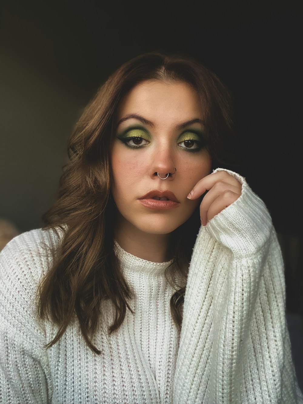 a woman with green eyes and a white sweater