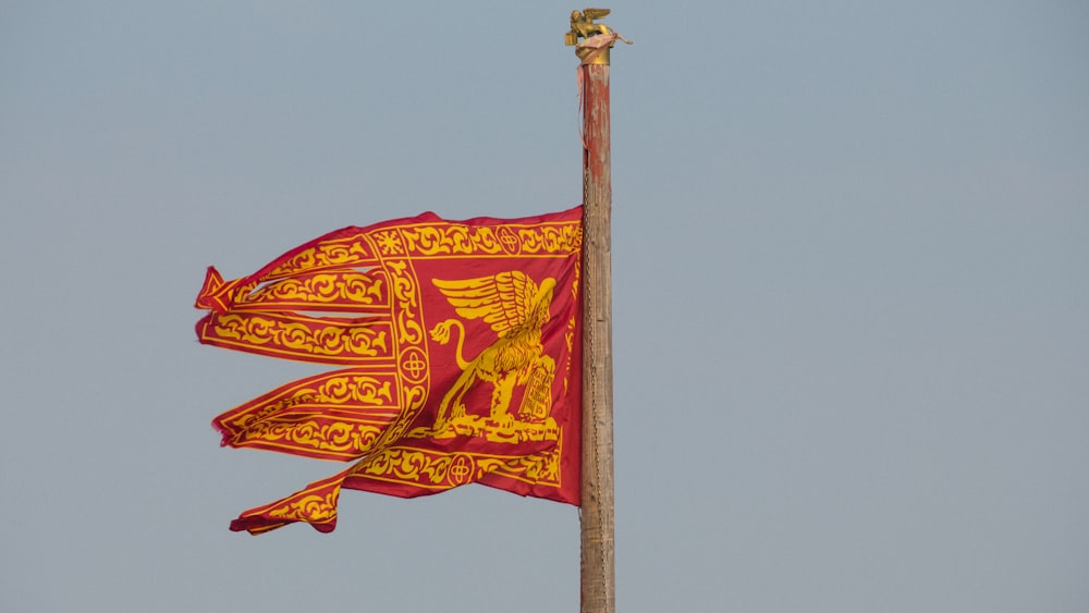 a red and yellow flag flying in the wind
