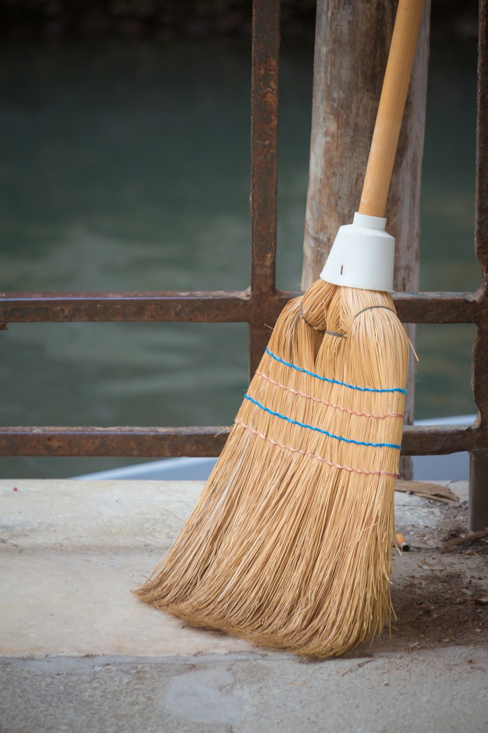 a broom sitting on the ground next to a body of water