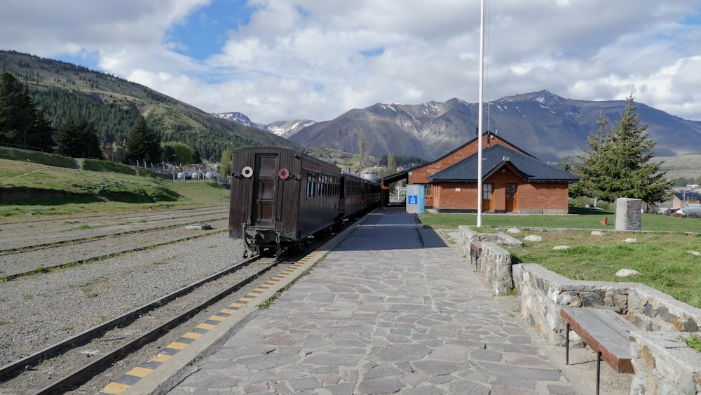 Un train descendant les voies à côté d’une colline verdoyante