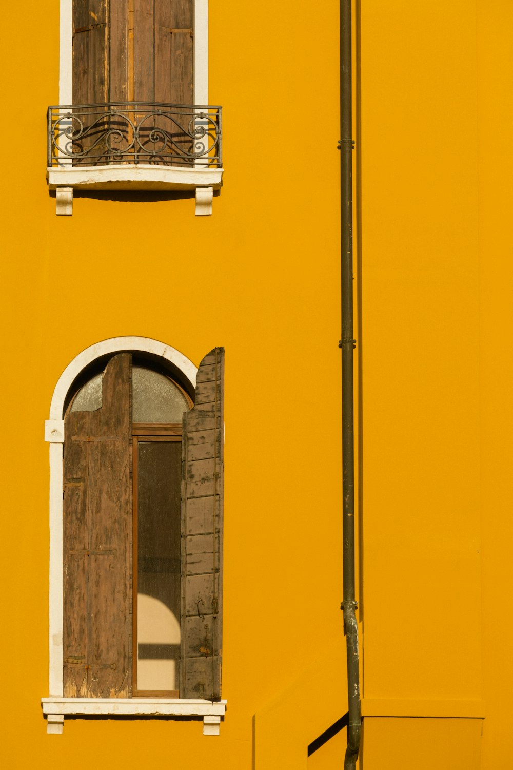a yellow building with two windows and a street light