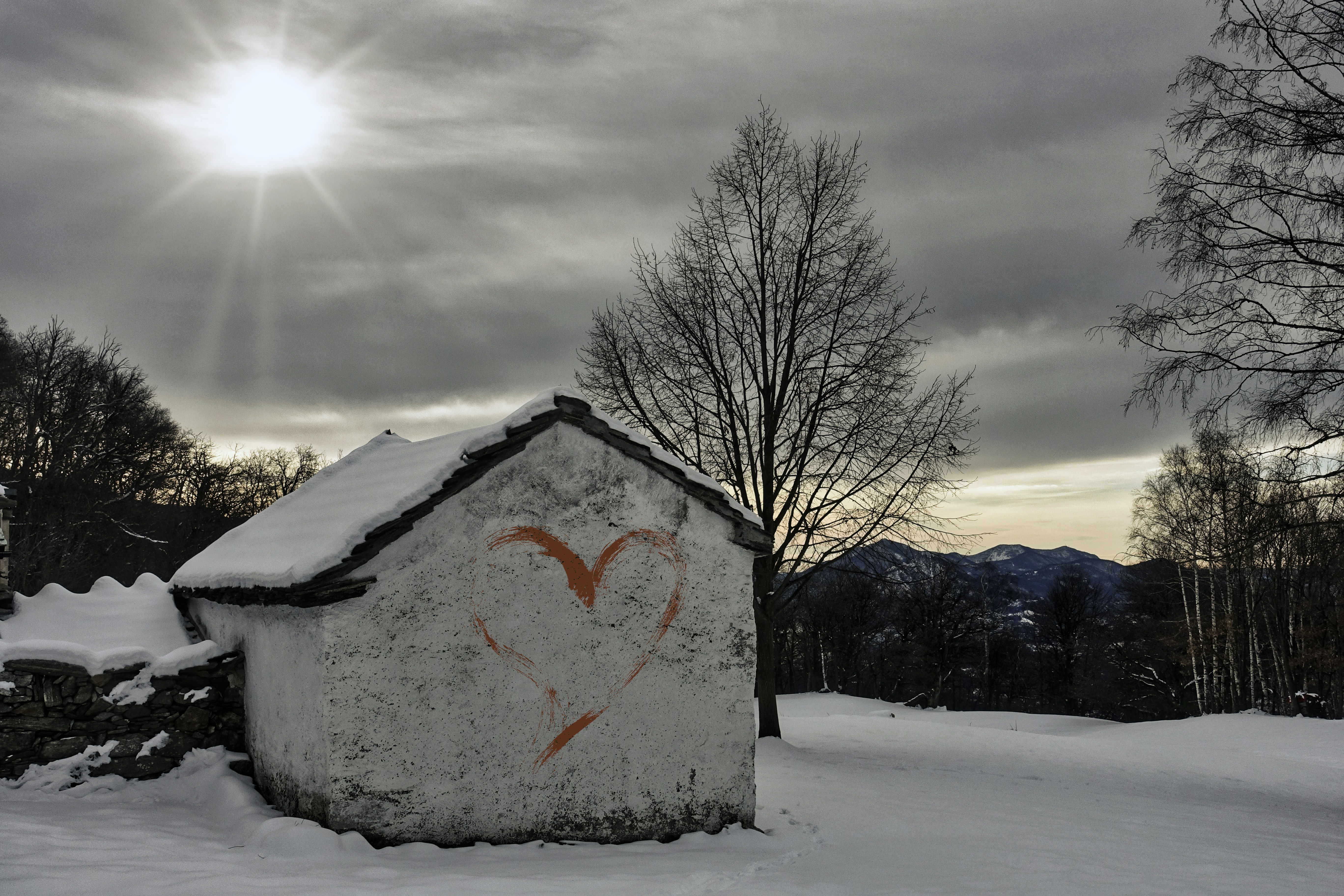 Una casa con un cuore disegnato sulla neve