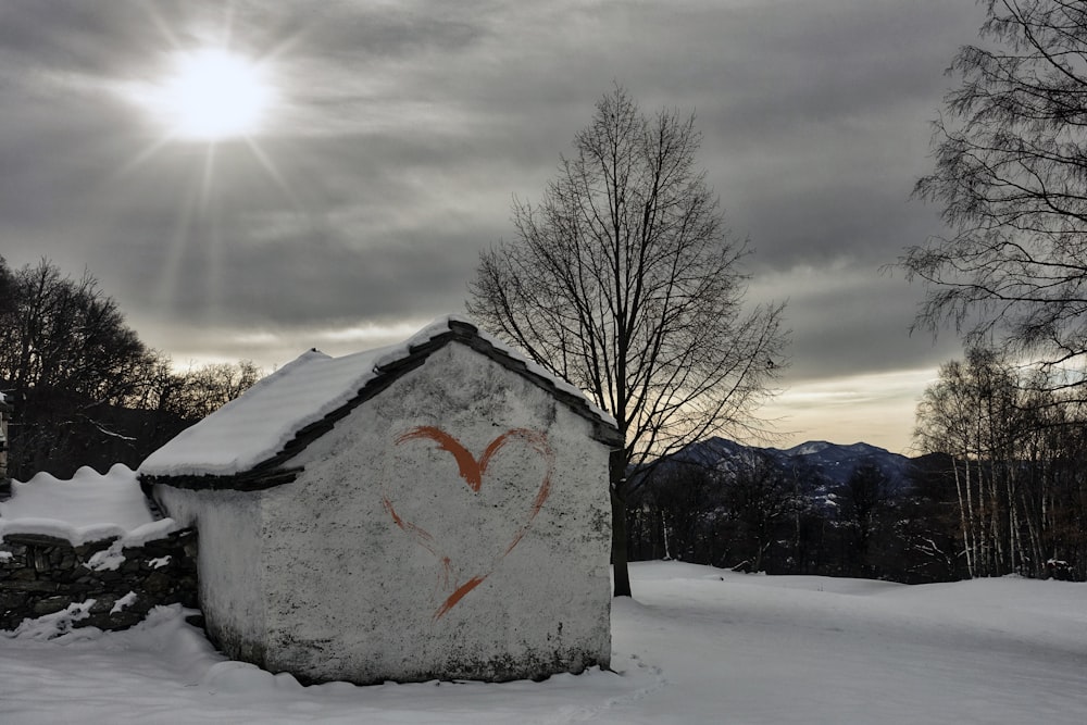 a house with a heart drawn on it in the snow
