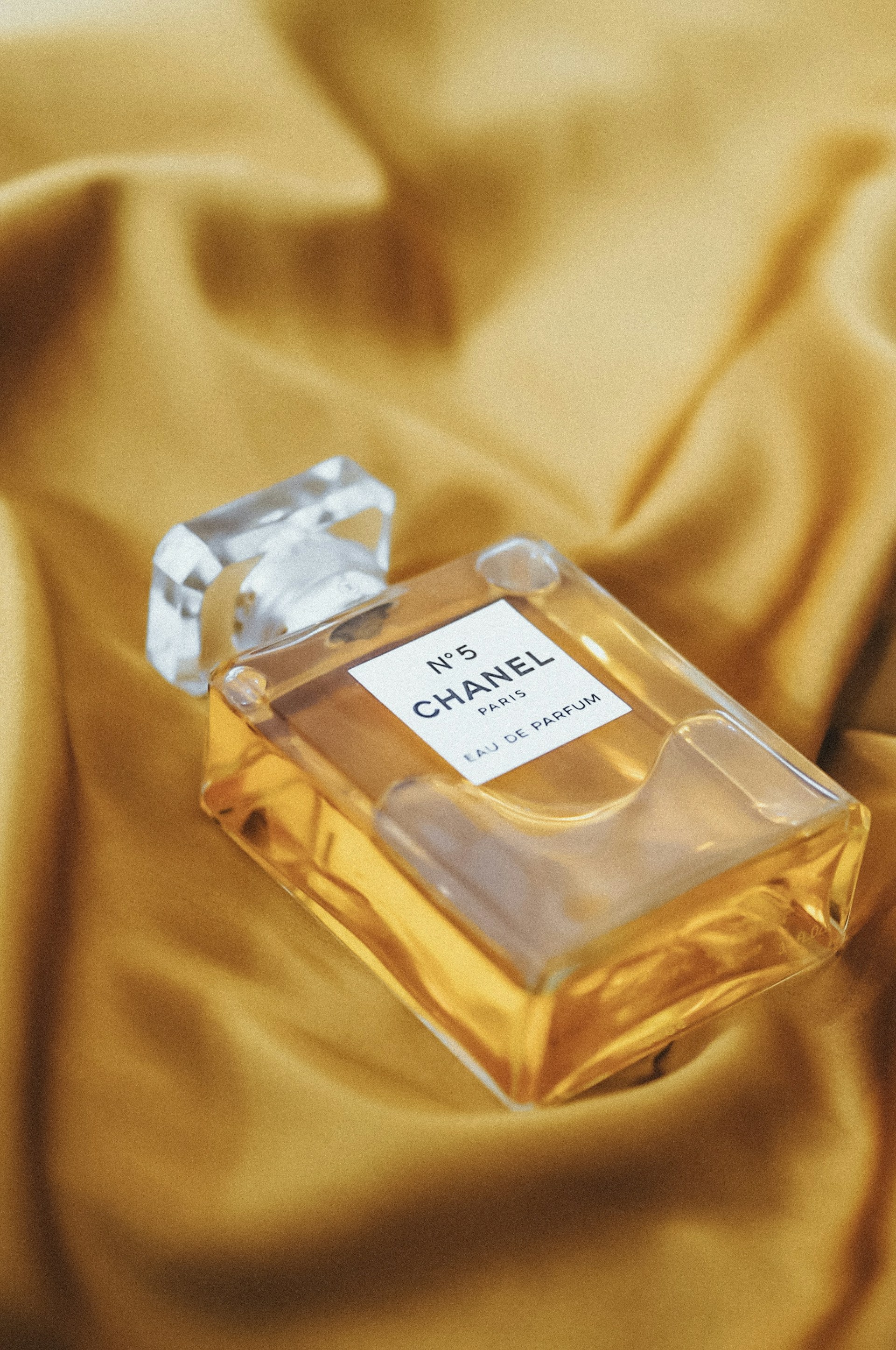 a bottle of chanel no 5 perfume on a bed