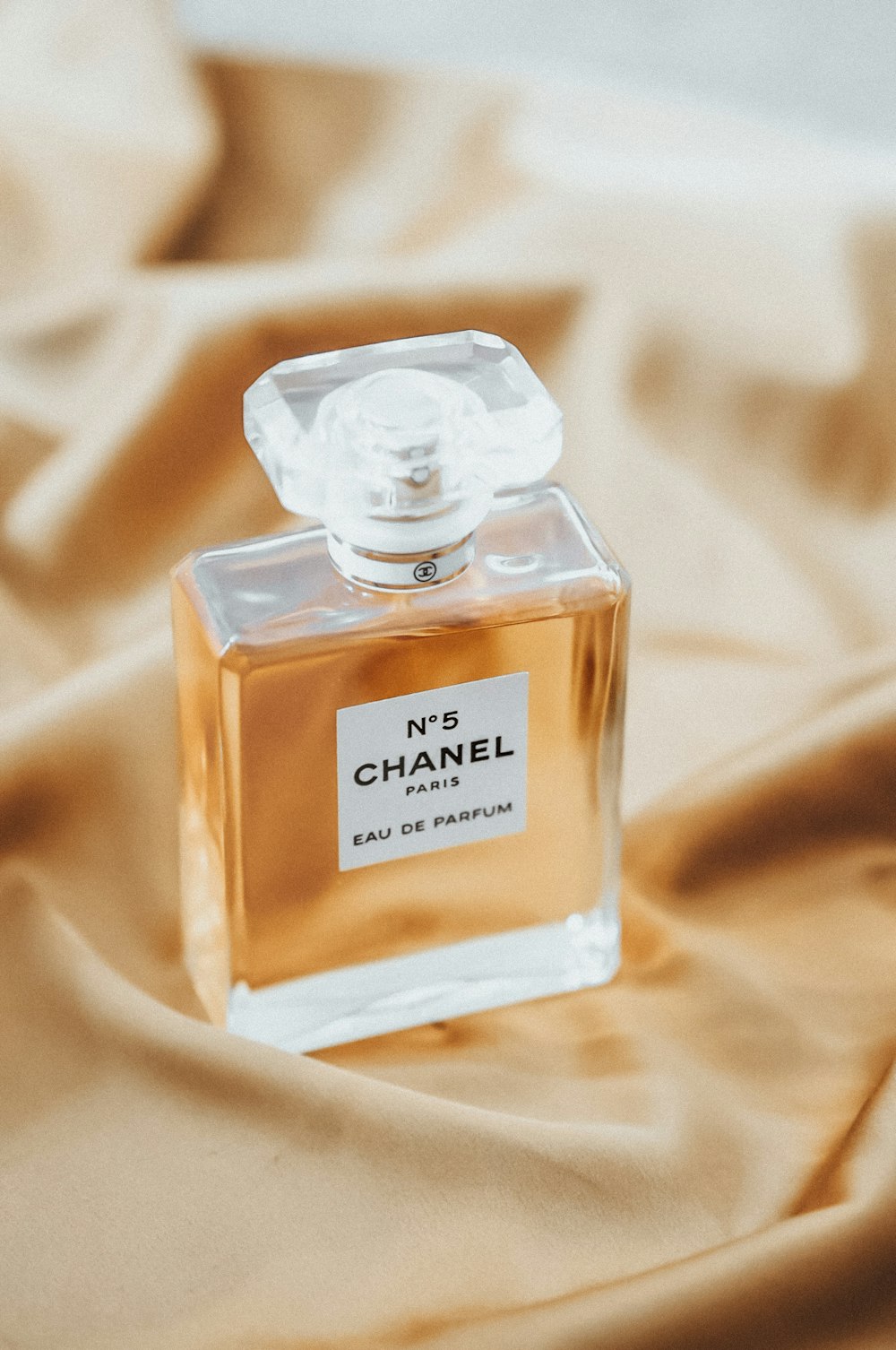 A bottle of chanel no 8 perfume sitting on a bed photo – Free Paris Image  on Unsplash