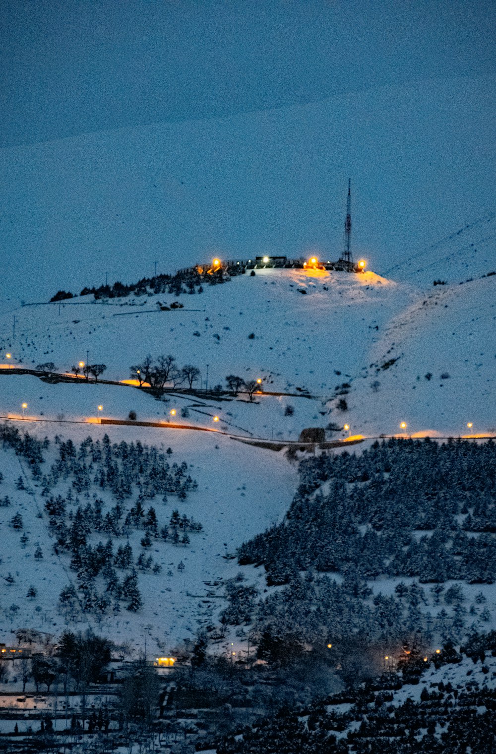 a snow covered mountain with a clock tower in the distance