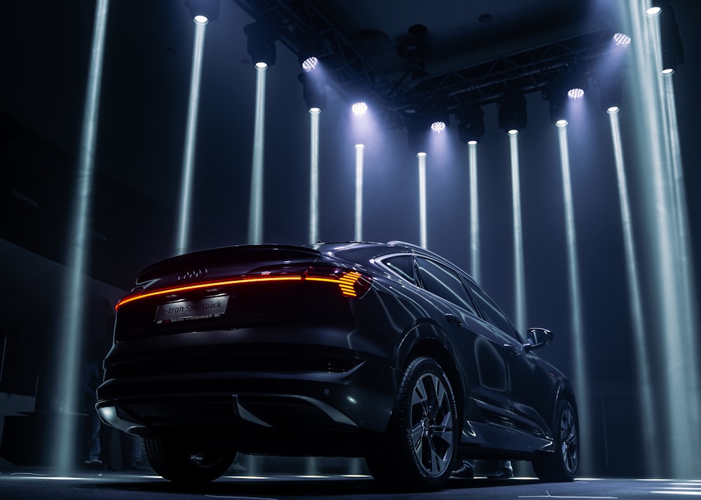 a car parked in front of a stage with lights