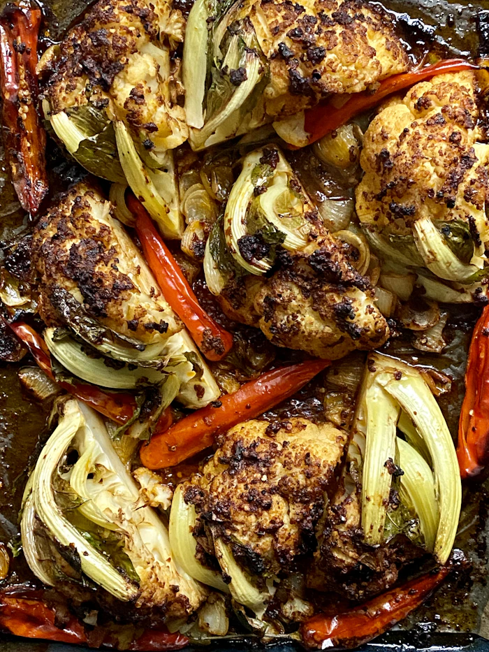 roasted chicken thighs with peppers and fennel on a baking tray